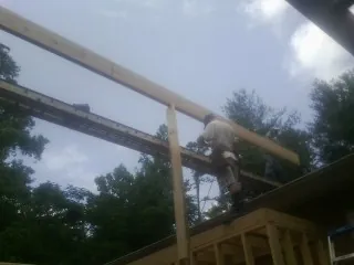 Carpenter setting a ridge beam over a new addition frame — Ice Dam Removal by Roofing Brothers in Neeses