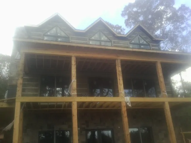 Dormers and porch framing on a large log home under construction — Roof Coating work by our crew in Neeses