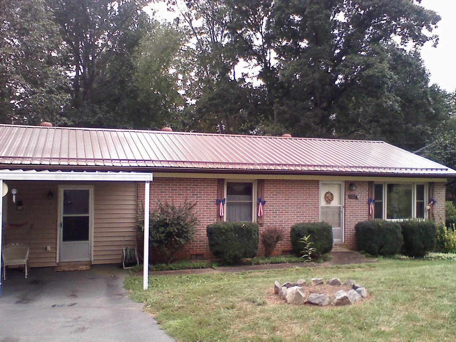 Bronze metal roof and carport on a brick ranch home — Roof Repair work by our crew in Neeses